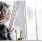 Frau guckt aus dem Fenster